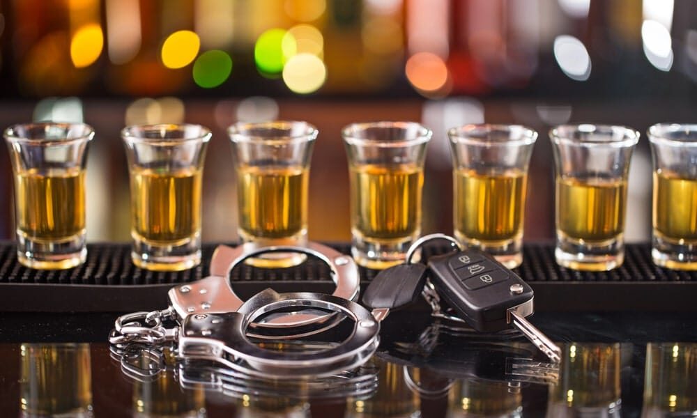 DUI vs DWI What Is the Difference in Morgan County Georgia Portrayed by shot glasses on a bar top, handcuffs and car keys.